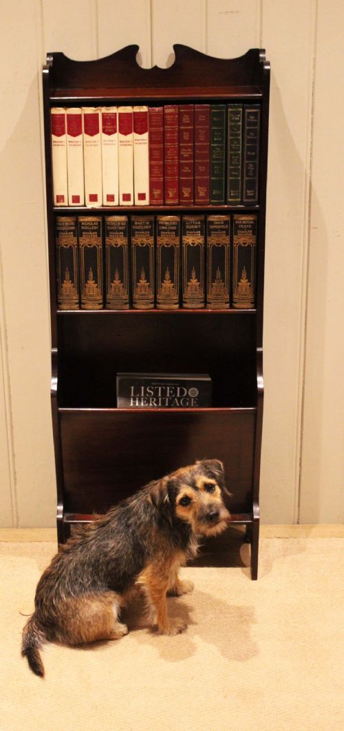 A narrow dark mahogany floor-standing shelf featuring two open upper book shelves and an angled lower magazine trough with a shaped top gallery. View XI