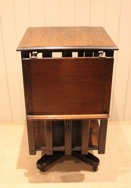 fig 1. A dark oak revolving bookcase featuring vertical slatted sides, an adjustable reading lectern, and a four-point base on castors.