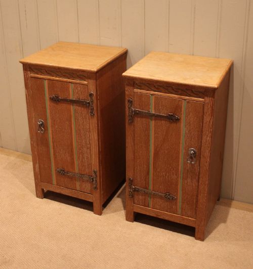 fig 1. A pair of limed oak bedside cabinets featuring panelled single doors, wrought iron strap hinges, and subtle green painted accents.