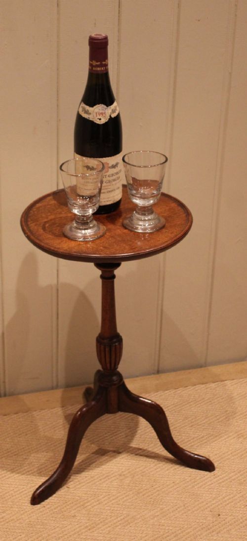 A mahogany wine table featuring a circular dished top supported by a turned reeded pedestal on three splayed cabriole legs. View VIII