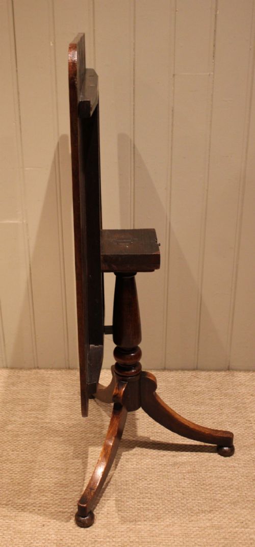 A late Georgian oak tilt-top table featuring a rectangular top with rounded corners, supported by a turned central column and a tripod base. View XI