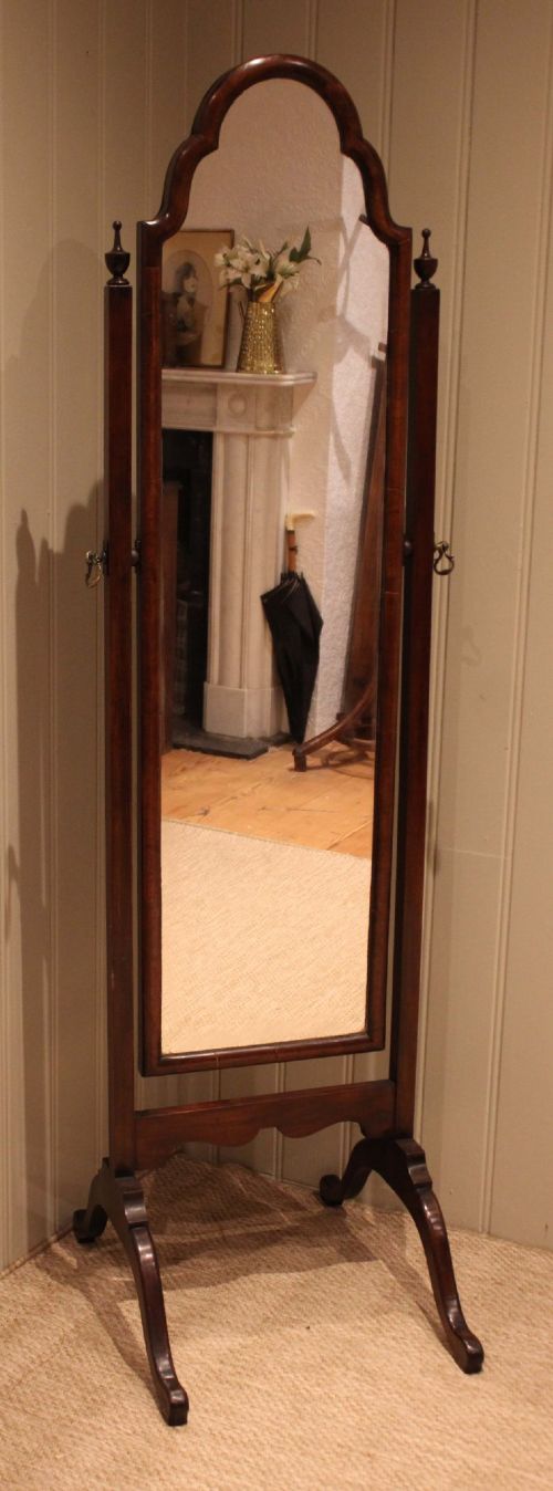 A mahogany cheval dressing mirror with an arched top frame, turned finials on the uprights, and splayed legs. View II