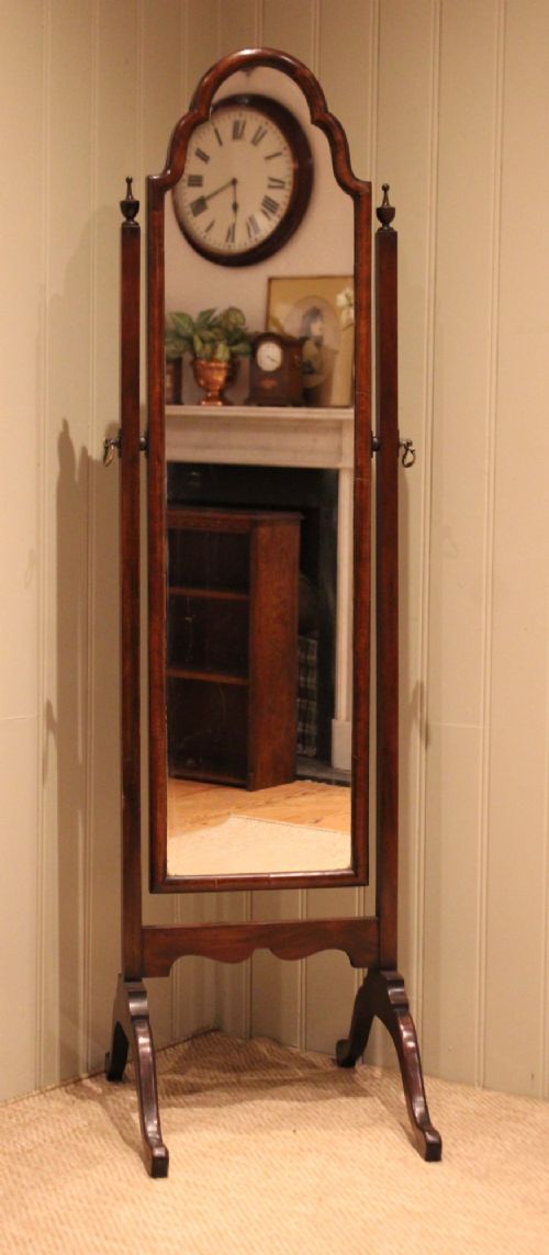 A mahogany cheval dressing mirror with an arched top frame, turned finials on the uprights, and splayed legs. View III