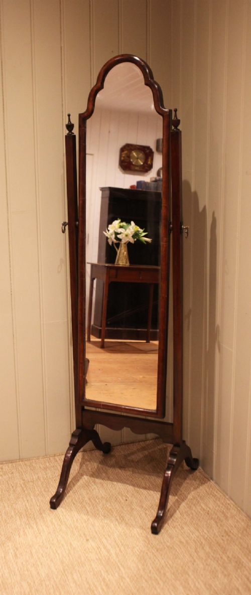 A mahogany cheval dressing mirror with an arched top frame, turned finials on the uprights, and splayed legs. View VIII