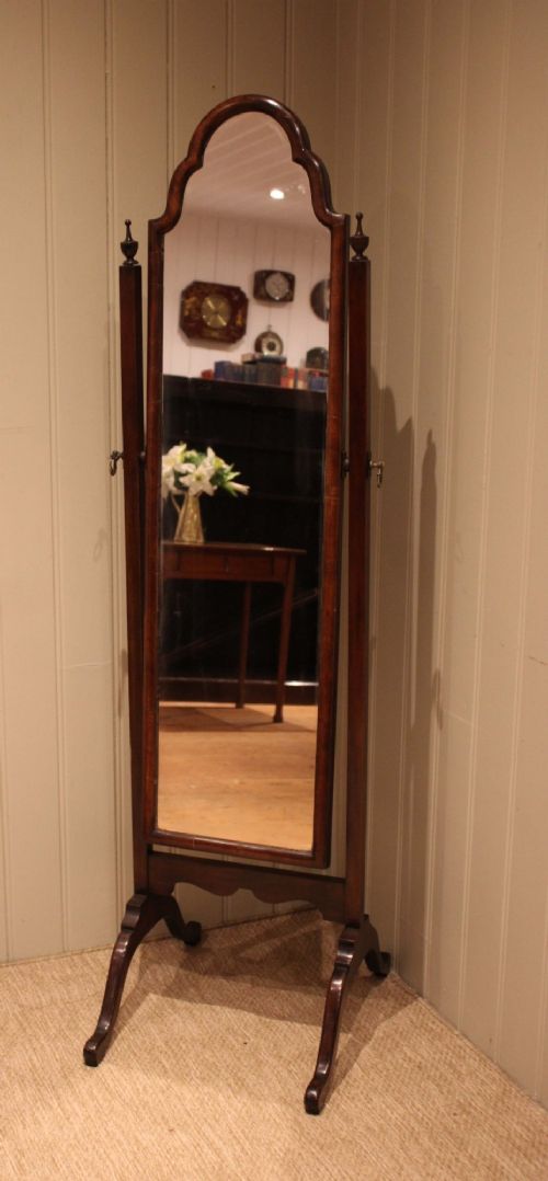 A mahogany cheval dressing mirror with an arched top frame, turned finials on the uprights, and splayed legs. View X