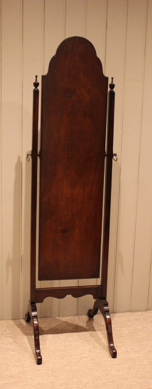A mahogany cheval dressing mirror with an arched top frame, turned finials on the uprights, and splayed legs. View XII
