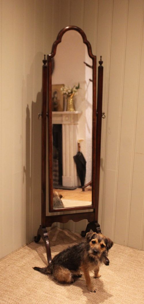 A mahogany cheval dressing mirror with an arched top frame, turned finials on the uprights, and splayed legs. View XIII