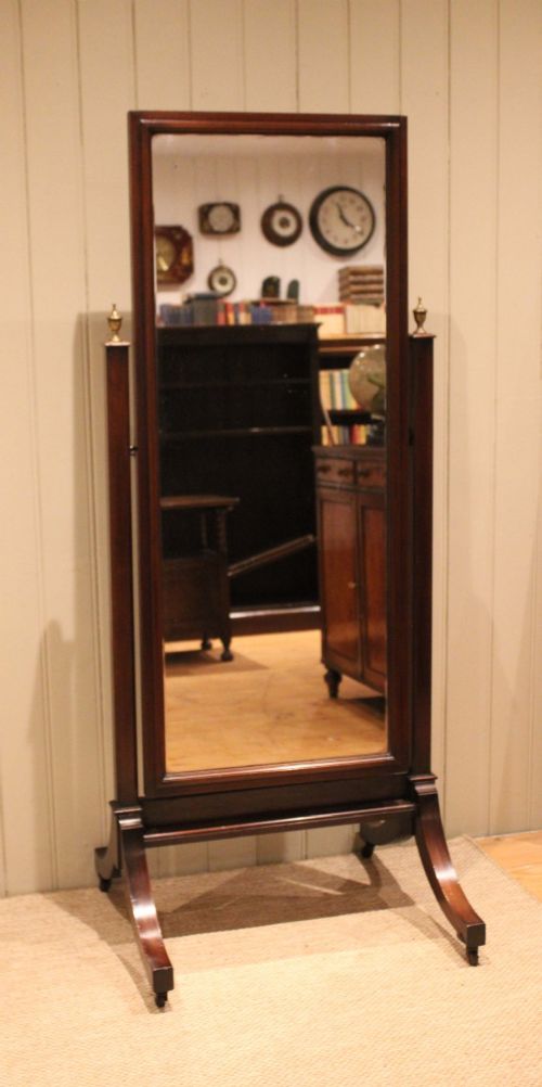 A late nineteenth-century mahogany cheval mirror featuring a rectangular swinging glass frame supported by upright pillars on splayed feet with brass castors. View V