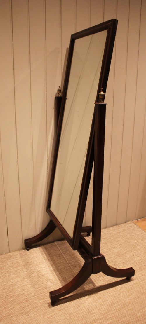 A late nineteenth-century mahogany cheval mirror featuring a rectangular swinging glass frame supported by upright pillars on splayed feet with brass castors. View VII