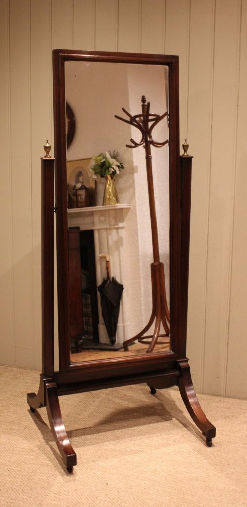 A late nineteenth-century mahogany cheval mirror featuring a rectangular swinging glass frame supported by upright pillars on splayed feet with brass castors. View VIII