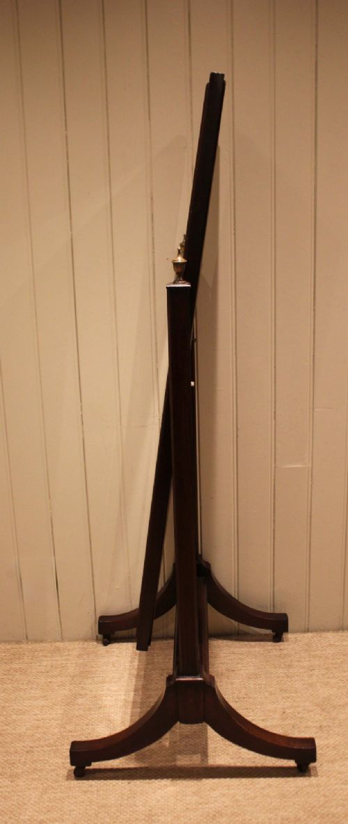 A late nineteenth-century mahogany cheval mirror featuring a rectangular swinging glass frame supported by upright pillars on splayed feet with brass castors. View IX