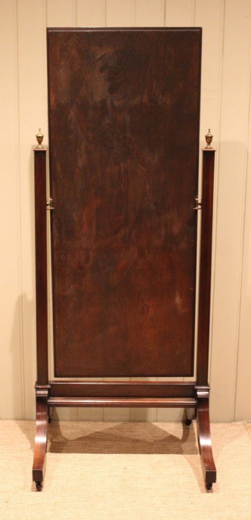 A late nineteenth-century mahogany cheval mirror featuring a rectangular swinging glass frame supported by upright pillars on splayed feet with brass castors. View X