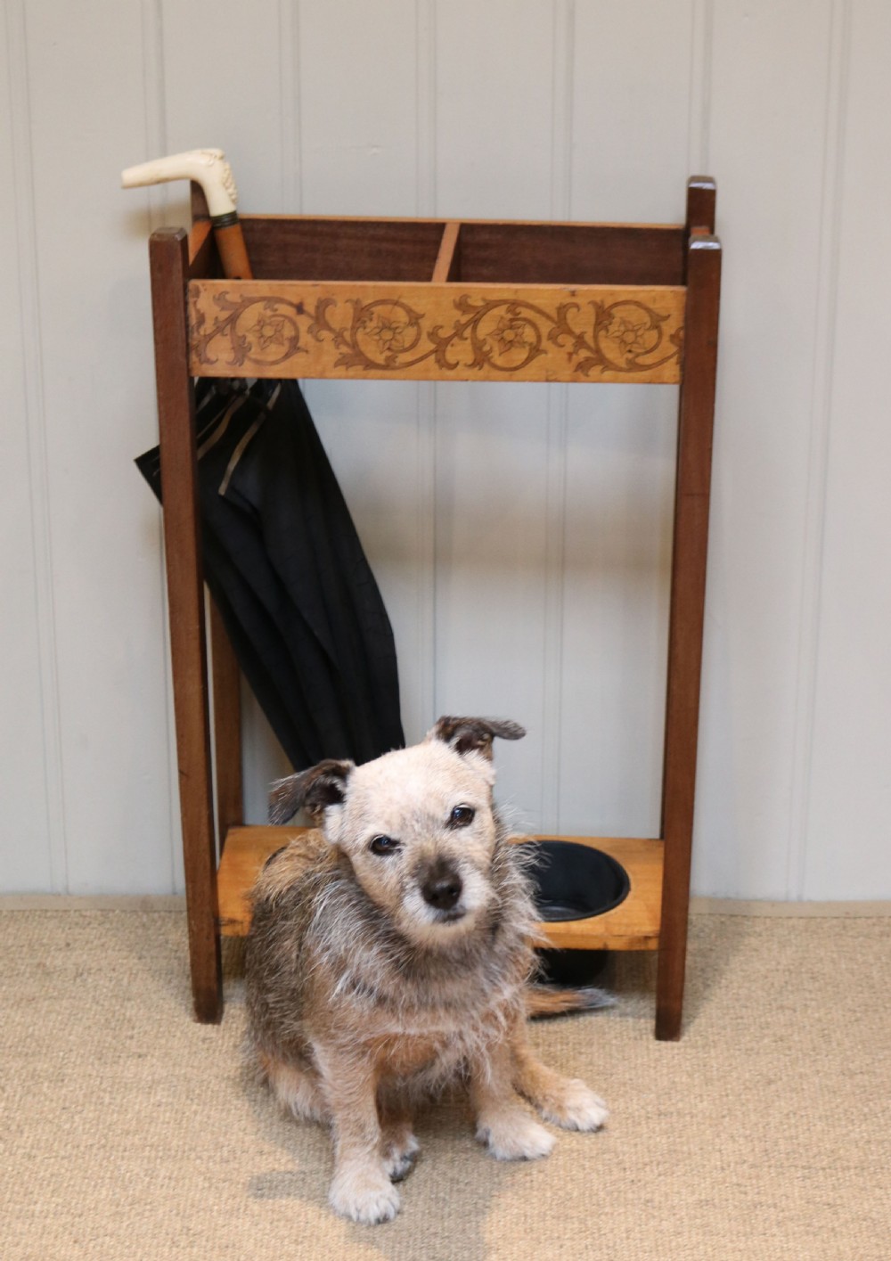 A dark wooden umbrella stand featuring a light inlaid maple top panel decorated with floral motifs, divided upper sections, and two circular black drip trays at the base. View VIII
