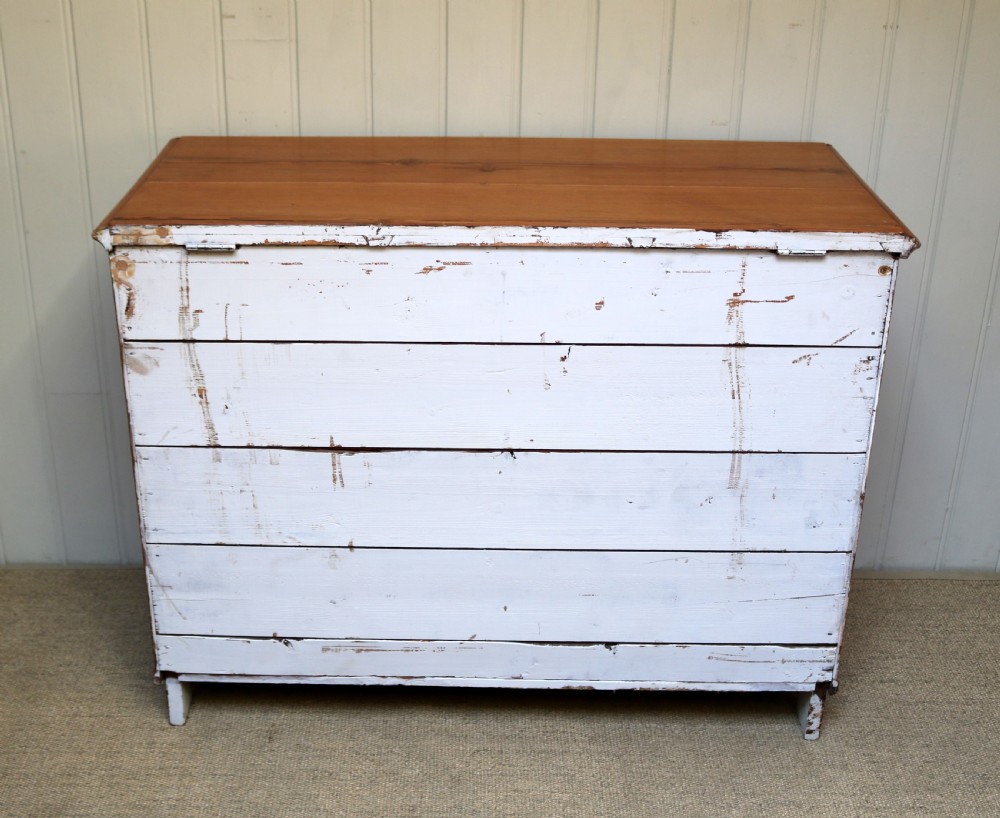 A rectangular warm pine storage box featuring three panelled front sections, a flat hinged top, and a shaped plinth base. View VIII