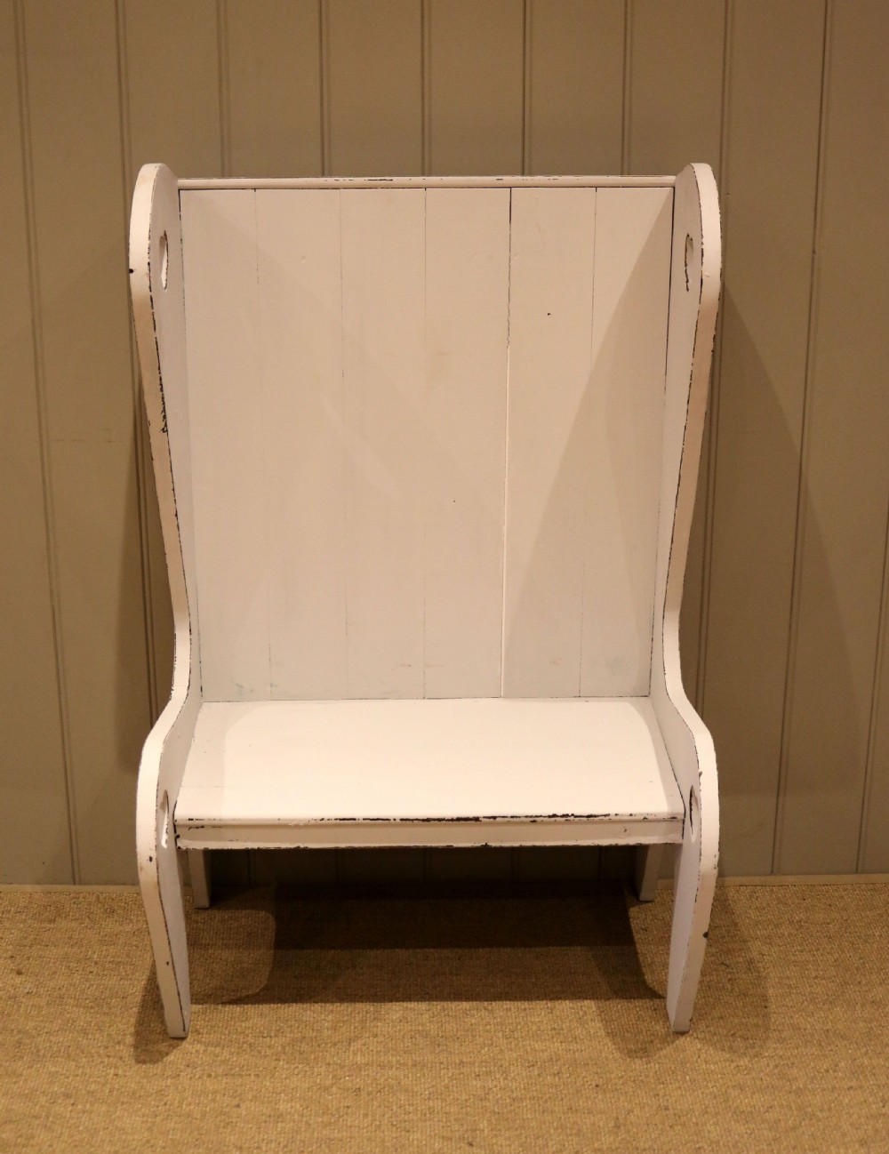 A small off-white painted wooden Arts and Crafts style high-backed settle featuring heart cut-outs on the side panels. View III