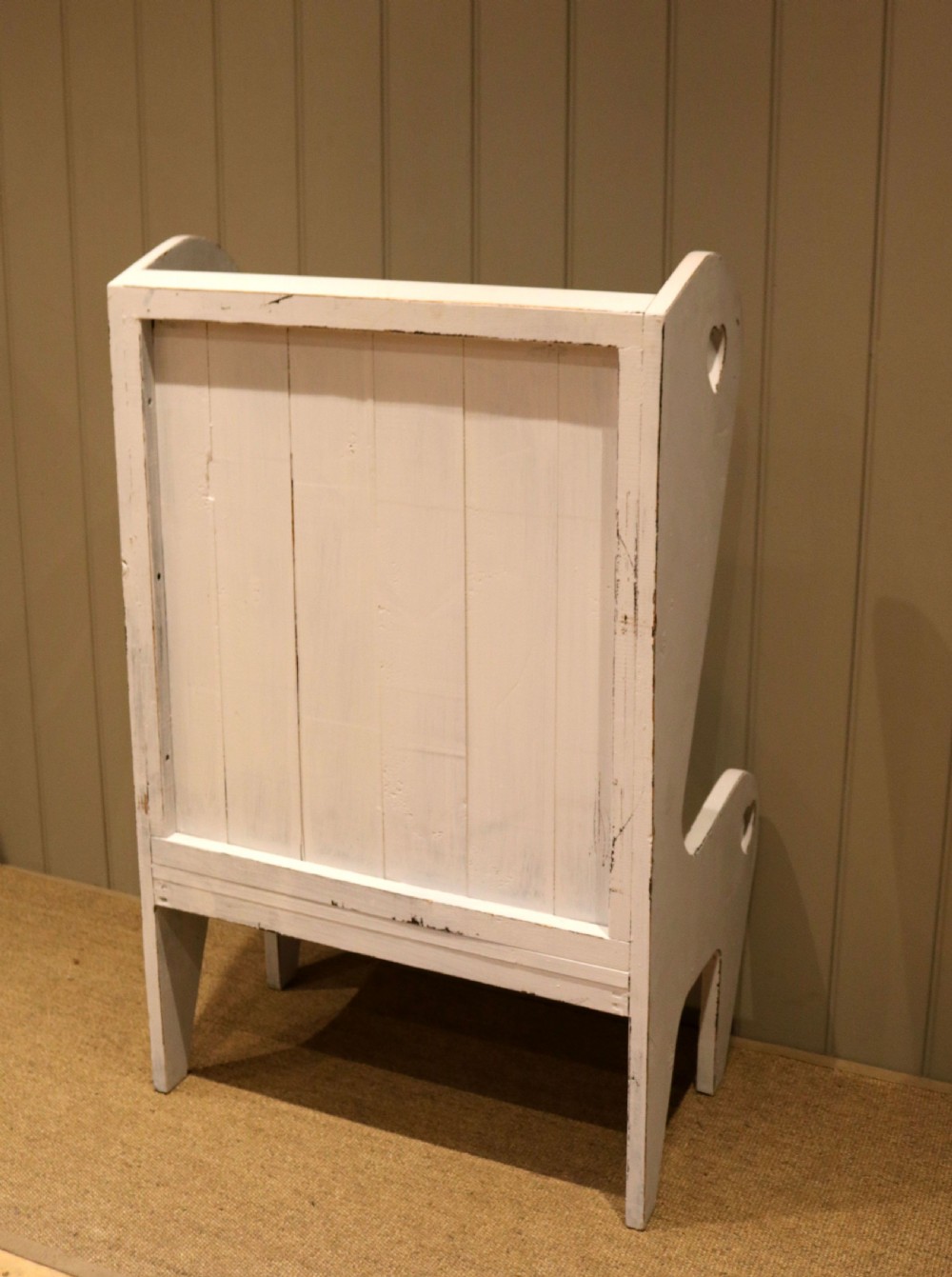 A small off-white painted wooden Arts and Crafts style high-backed settle featuring heart cut-outs on the side panels. View VIII