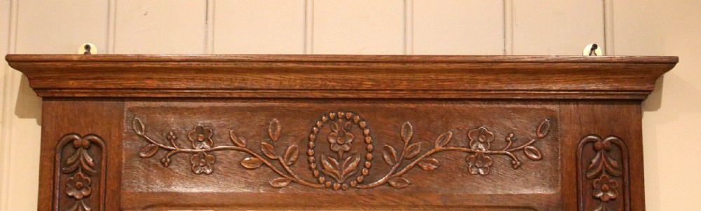 A large vertical French oak wall mirror featuring a carved floral frieze and a moulded upper cornice. View VII