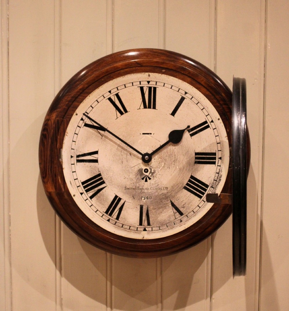 A circular 1940s wall clock featuring a turned beech wood bezel surround and an aged dial with black Roman numerals. View III