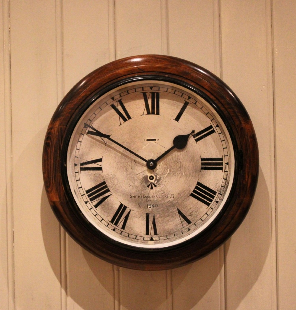 A circular 1940s wall clock featuring a turned beech wood bezel surround and an aged dial with black Roman numerals. View IV