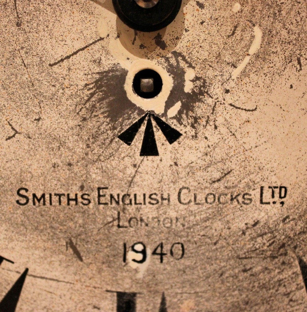 A circular 1940s wall clock featuring a turned beech wood bezel surround and an aged dial with black Roman numerals. View VII