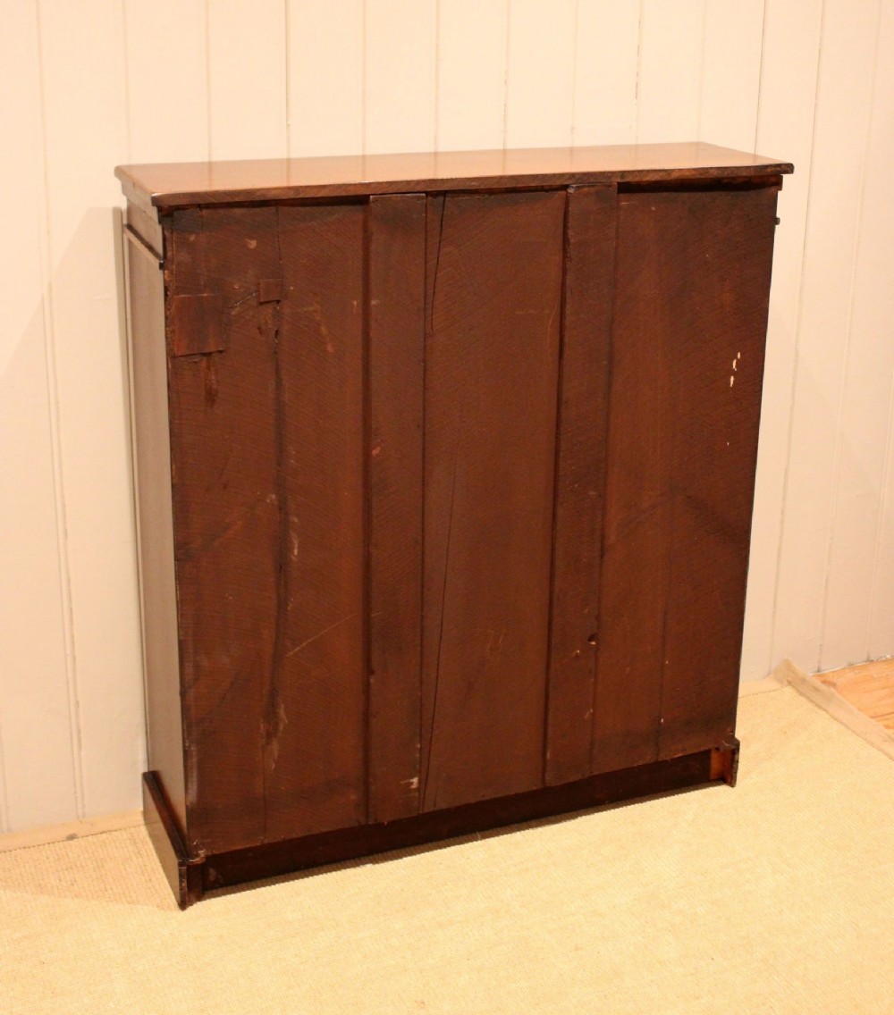 A late nineteenth-century dark mahogany bookcase with two glazed doors and interior shelves containing rows of books. View XIII