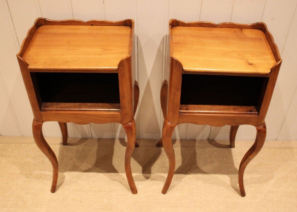 A pair of warm brown cherry wood bedside cabinets featuring open shelf compartments, scalloped top galleries, and slender cabriole legs. View VI