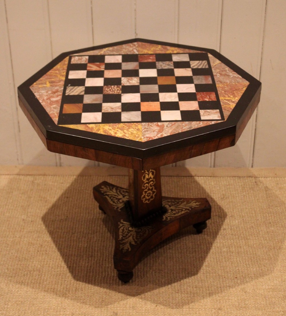 An octagonal Regency rosewood occasional table featuring an inlaid specimen marble chess board top supported by a central column and triform base.