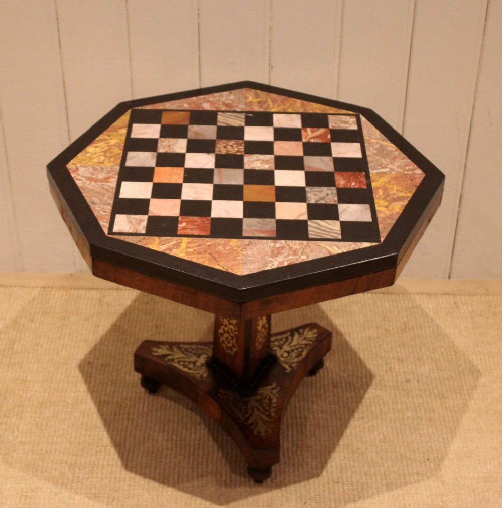 An octagonal Regency rosewood occasional table featuring an inlaid specimen marble chess board top supported by a central column and triform base. View IV