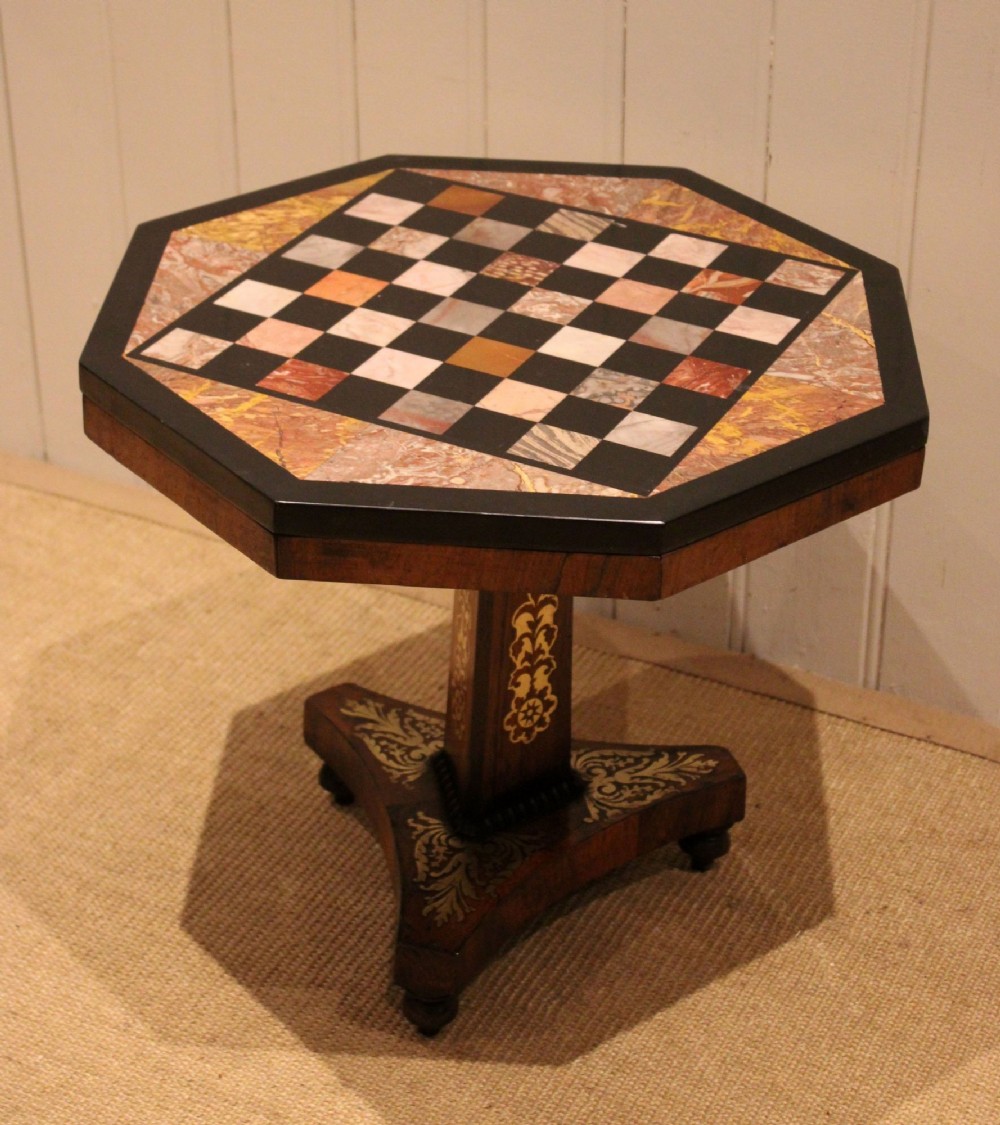 An octagonal Regency rosewood occasional table featuring an inlaid specimen marble chess board top supported by a central column and triform base. View V