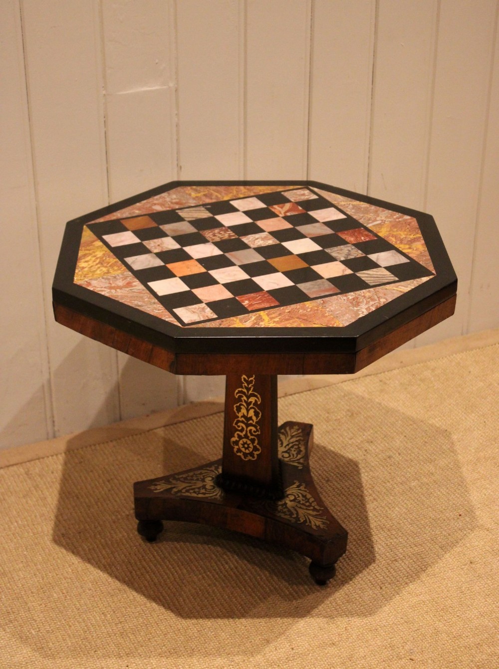 An octagonal Regency rosewood occasional table featuring an inlaid specimen marble chess board top supported by a central column and triform base. View IX