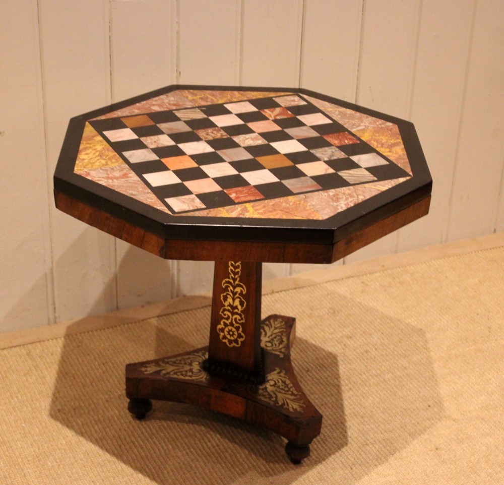 An octagonal Regency rosewood occasional table featuring an inlaid specimen marble chess board top supported by a central column and triform base. View X