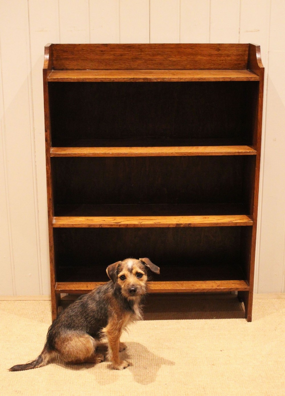 A golden oak open bookcase featuring four tiered shelves filled with antique books and a shaped top upstand gallery. View IV