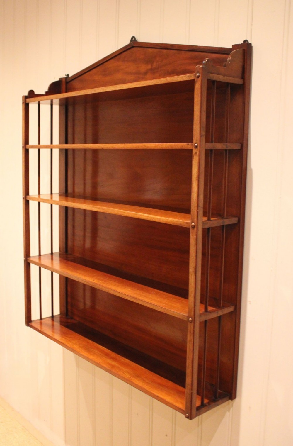 A four-tier mahogany wall-mounted shelving unit featuring open spindled sides and a peaked pediment top. View II