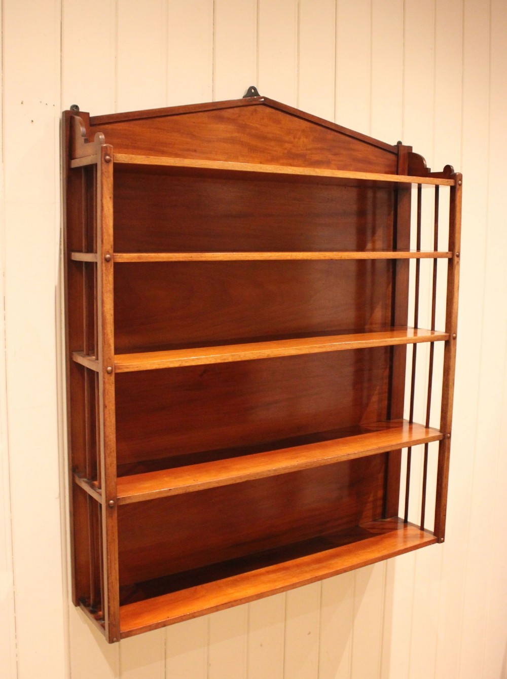 A four-tier mahogany wall-mounted shelving unit featuring open spindled sides and a peaked pediment top. View IV