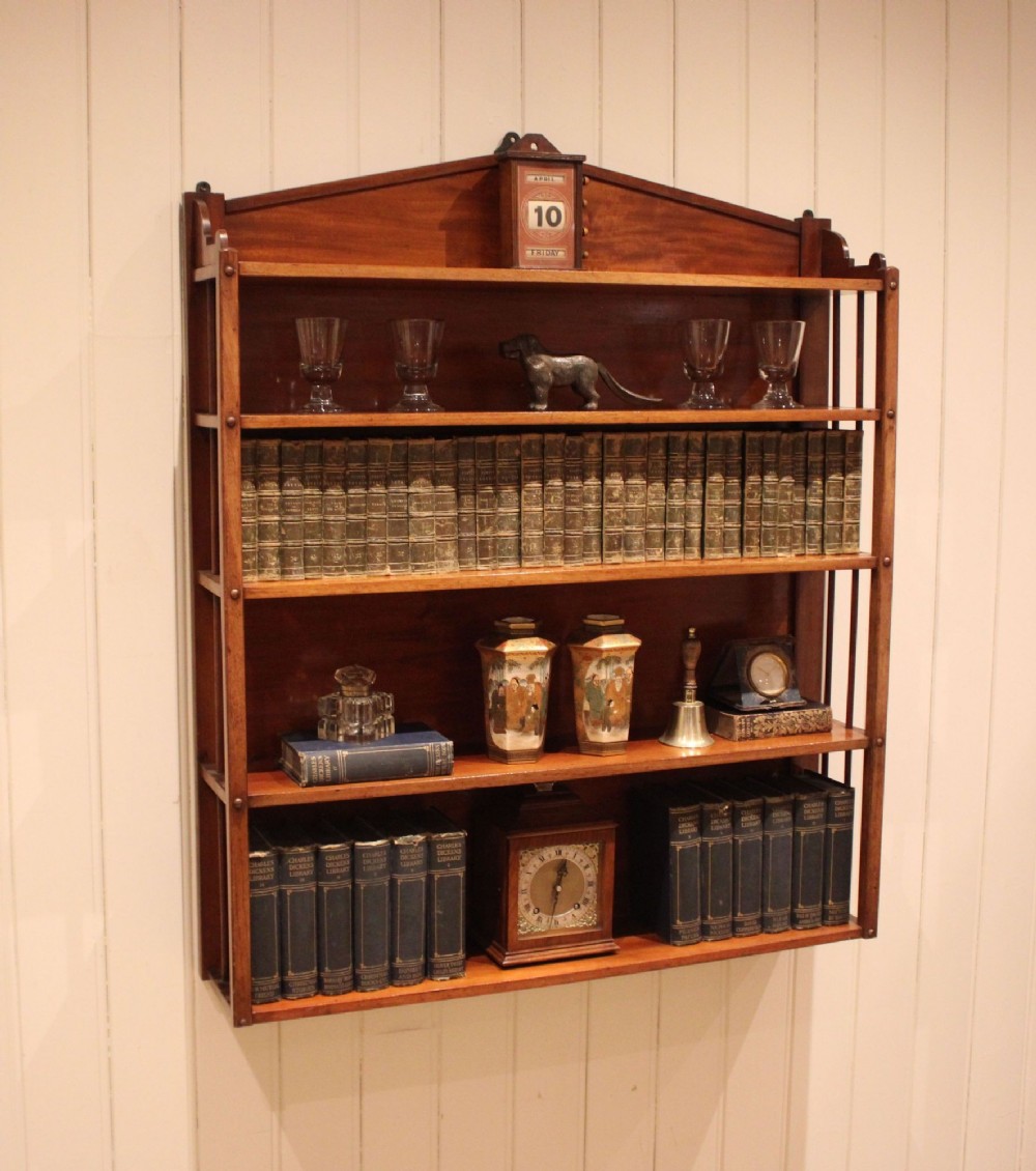 A four-tier mahogany wall-mounted shelving unit featuring open spindled sides and a peaked pediment top. View V