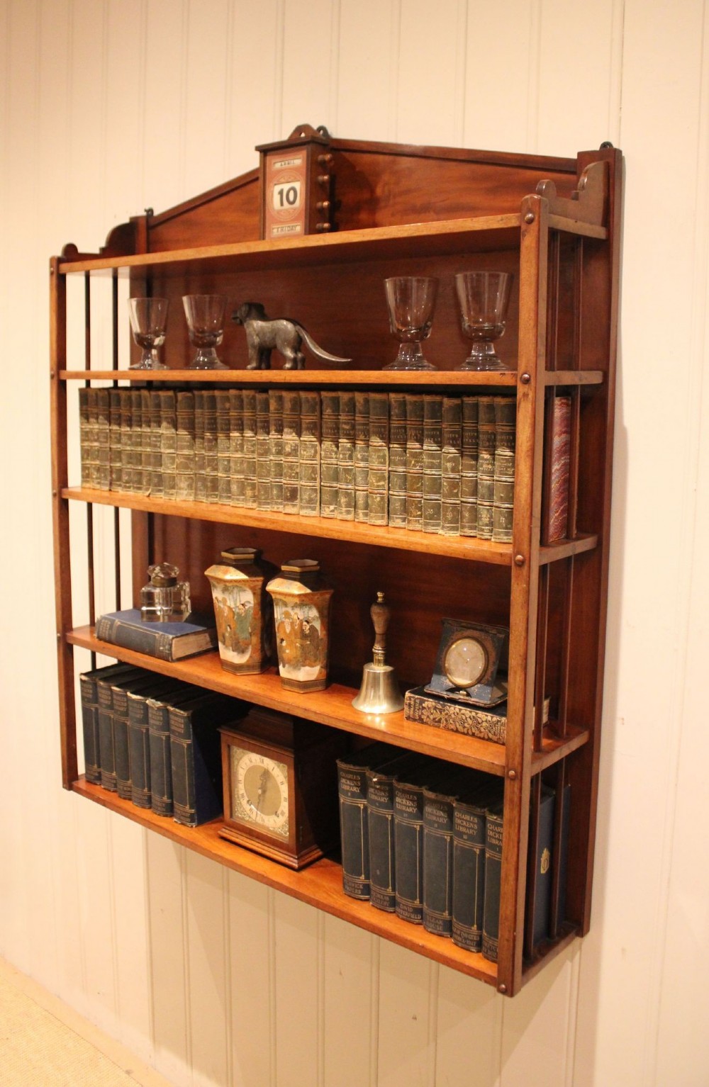 A four-tier mahogany wall-mounted shelving unit featuring open spindled sides and a peaked pediment top. View VII