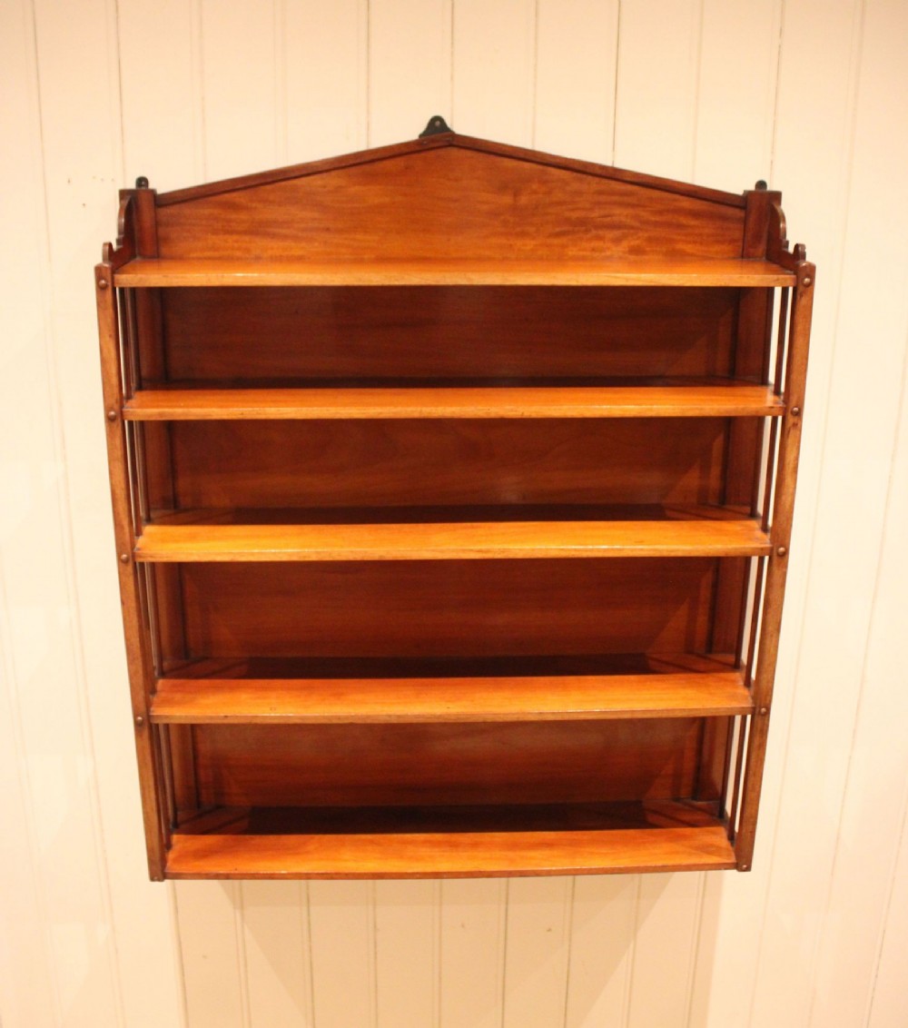 A four-tier mahogany wall-mounted shelving unit featuring open spindled sides and a peaked pediment top. View VIII