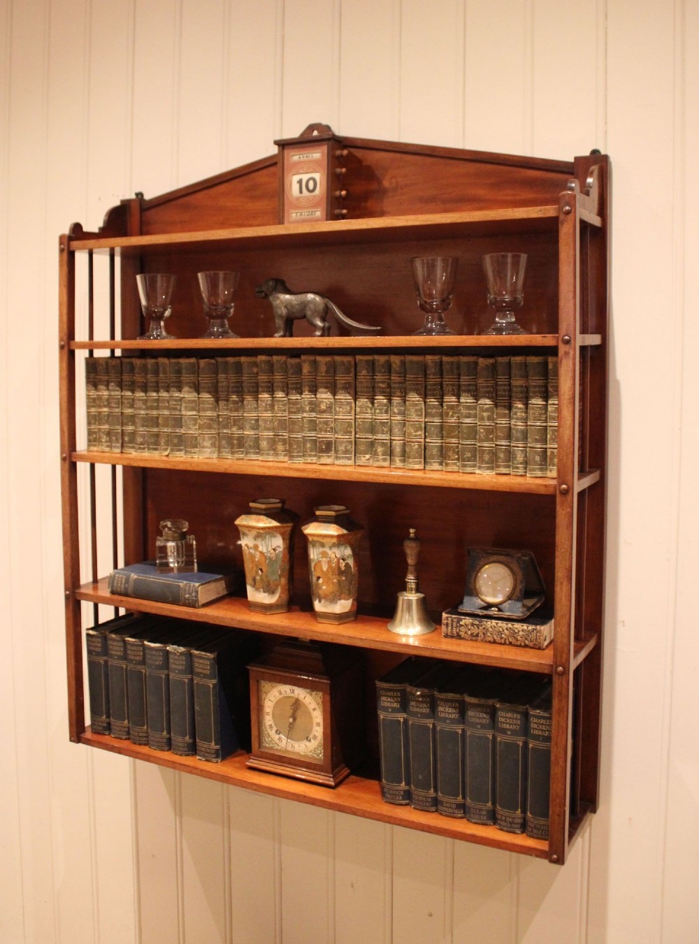 A four-tier mahogany wall-mounted shelving unit featuring open spindled sides and a peaked pediment top. View IX
