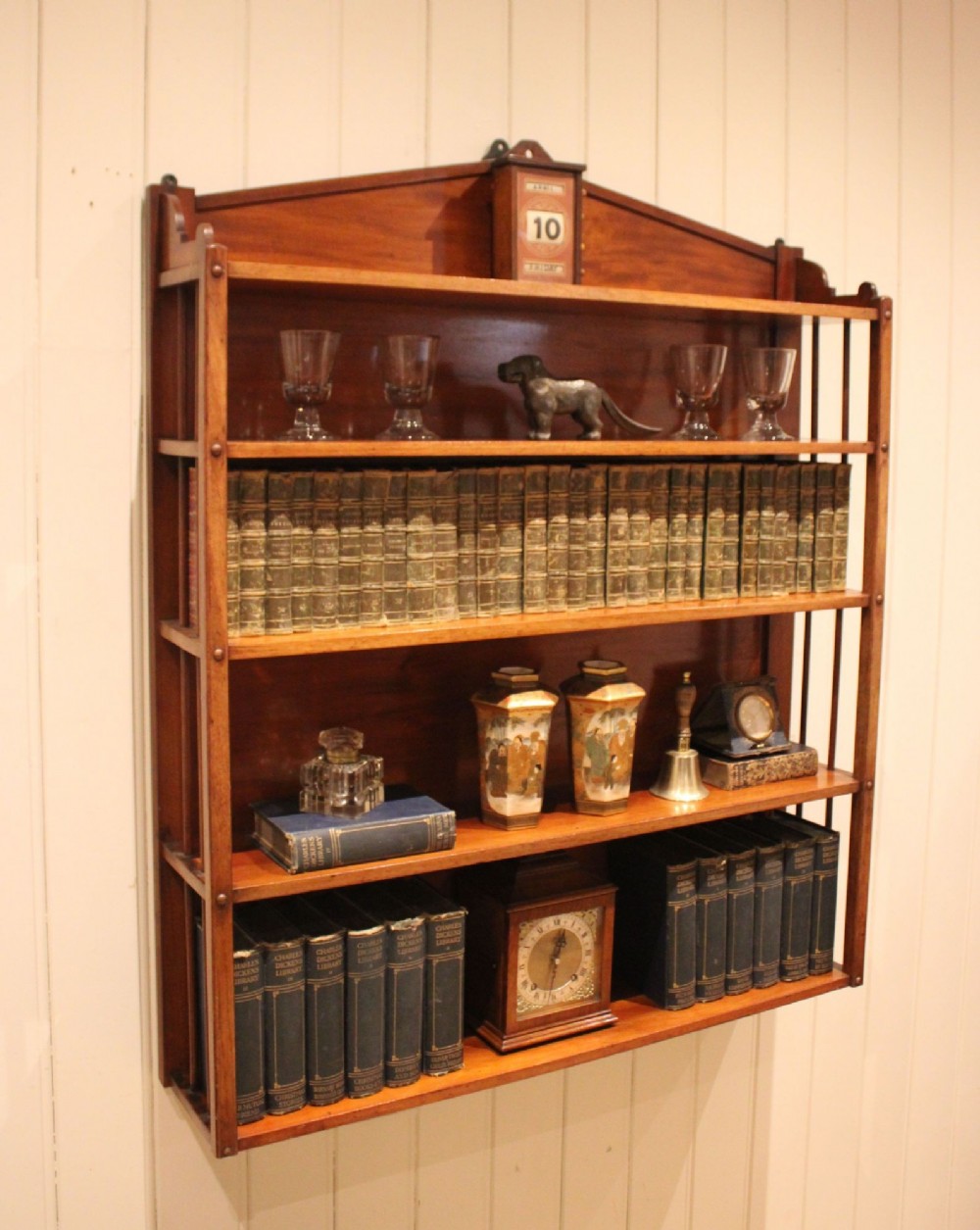 A four-tier mahogany wall-mounted shelving unit featuring open spindled sides and a peaked pediment top. View XI