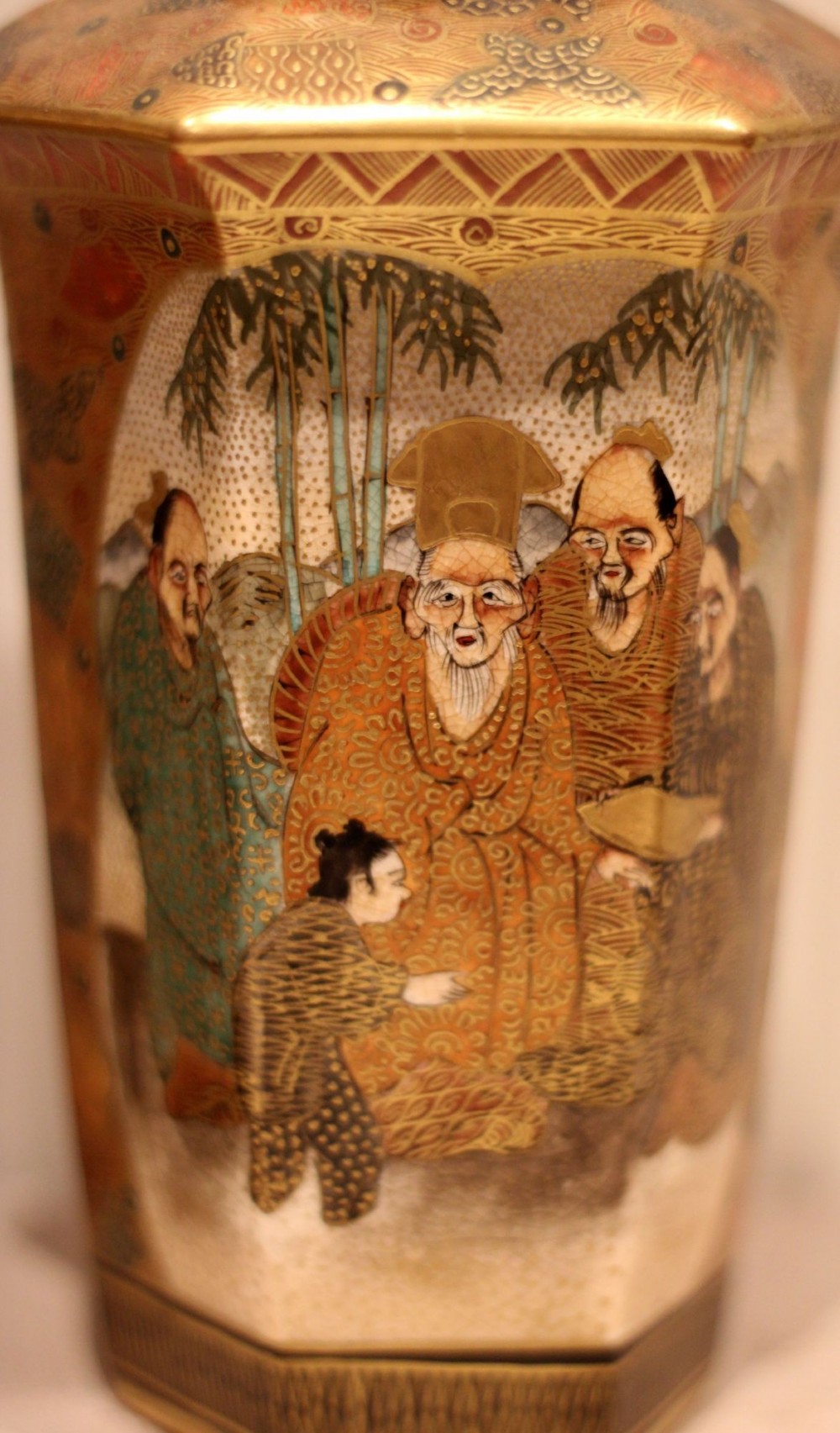 A pair of hexagonal Japanese Satsuma ceramic vases painted with figural scenes, mountain landscapes, and heavy gold enamel detailing. View IV