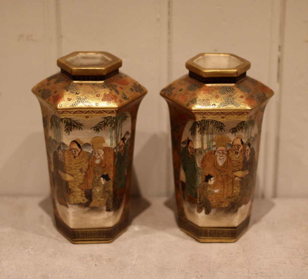 A pair of hexagonal Japanese Satsuma ceramic vases painted with figural scenes, mountain landscapes, and heavy gold enamel detailing. View VI