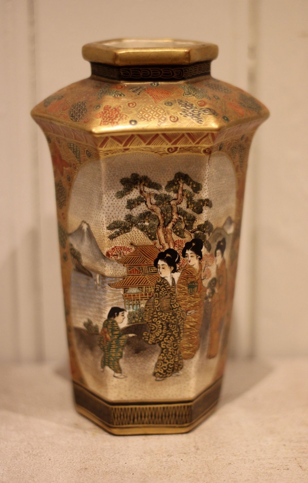 A pair of hexagonal Japanese Satsuma ceramic vases painted with figural scenes, mountain landscapes, and heavy gold enamel detailing. View VII