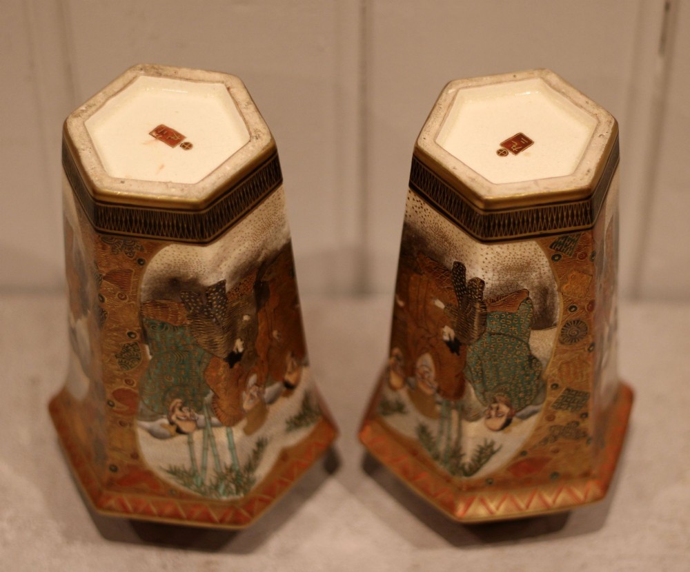 A pair of hexagonal Japanese Satsuma ceramic vases painted with figural scenes, mountain landscapes, and heavy gold enamel detailing. View X