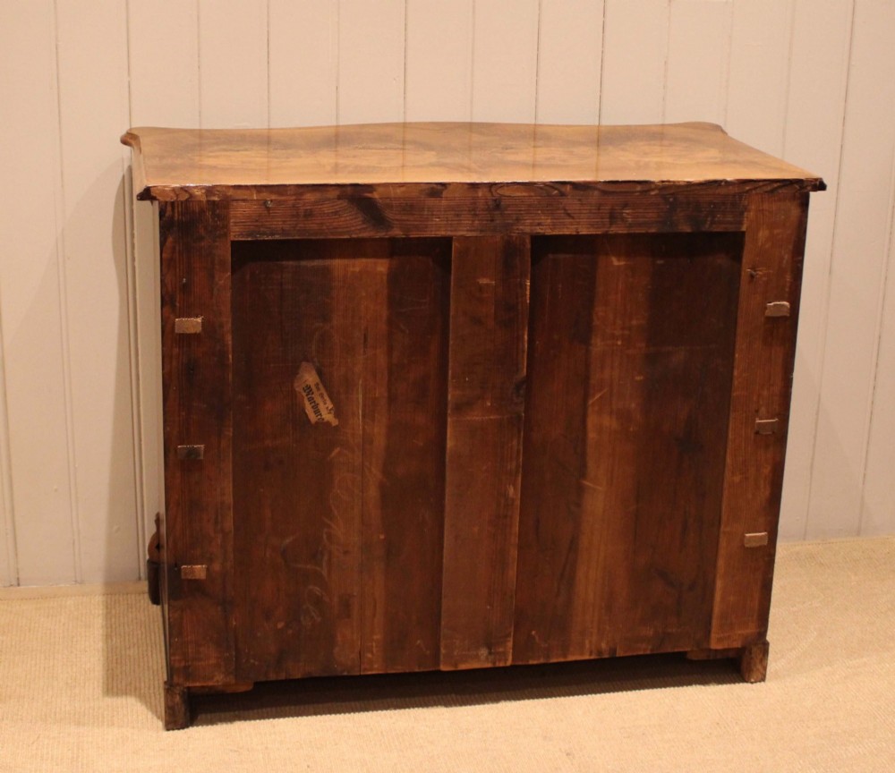 A mid-19th century burr walnut chest of four graduated drawers with a serpentine contoured front and brass drop handles. View X