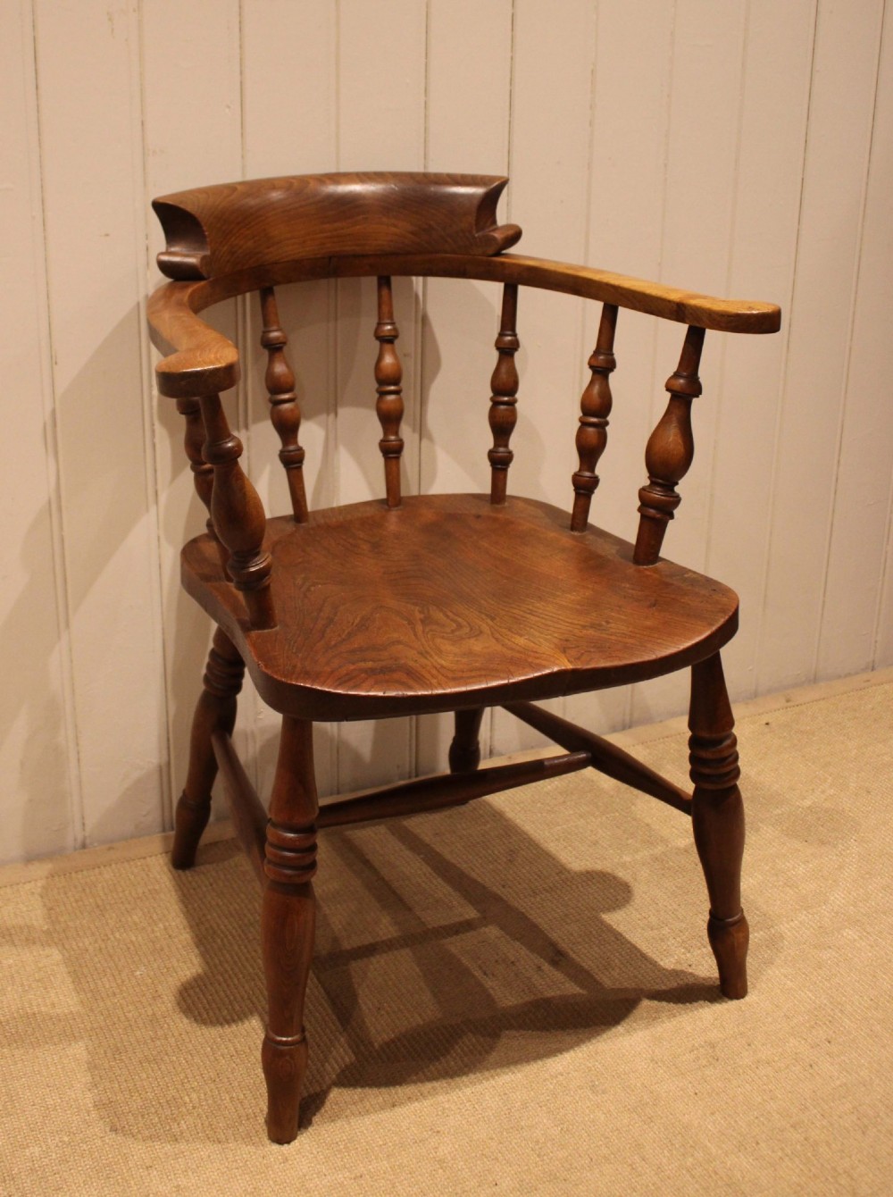 A late 19th-century wooden smokers bow armchair featuring a curved top rail, turned spindles, contoured saddle seat, and turned legs. View II