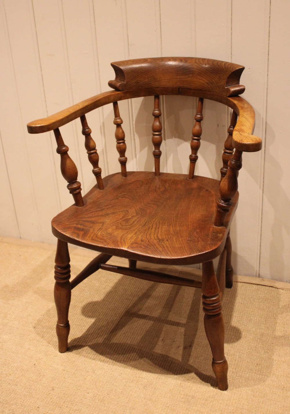 A late 19th-century wooden smokers bow armchair featuring a curved top rail, turned spindles, contoured saddle seat, and turned legs. View III