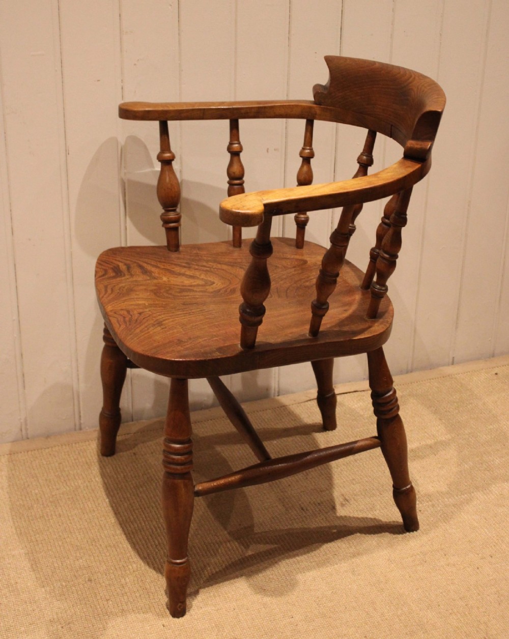 A late 19th-century wooden smokers bow armchair featuring a curved top rail, turned spindles, contoured saddle seat, and turned legs. View VIII