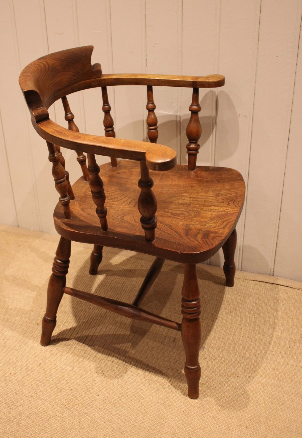 A late 19th-century wooden smokers bow armchair featuring a curved top rail, turned spindles, contoured saddle seat, and turned legs. View IX