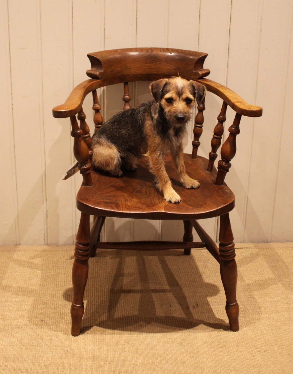 A late 19th-century wooden smokers bow armchair featuring a curved top rail, turned spindles, contoured saddle seat, and turned legs. View X