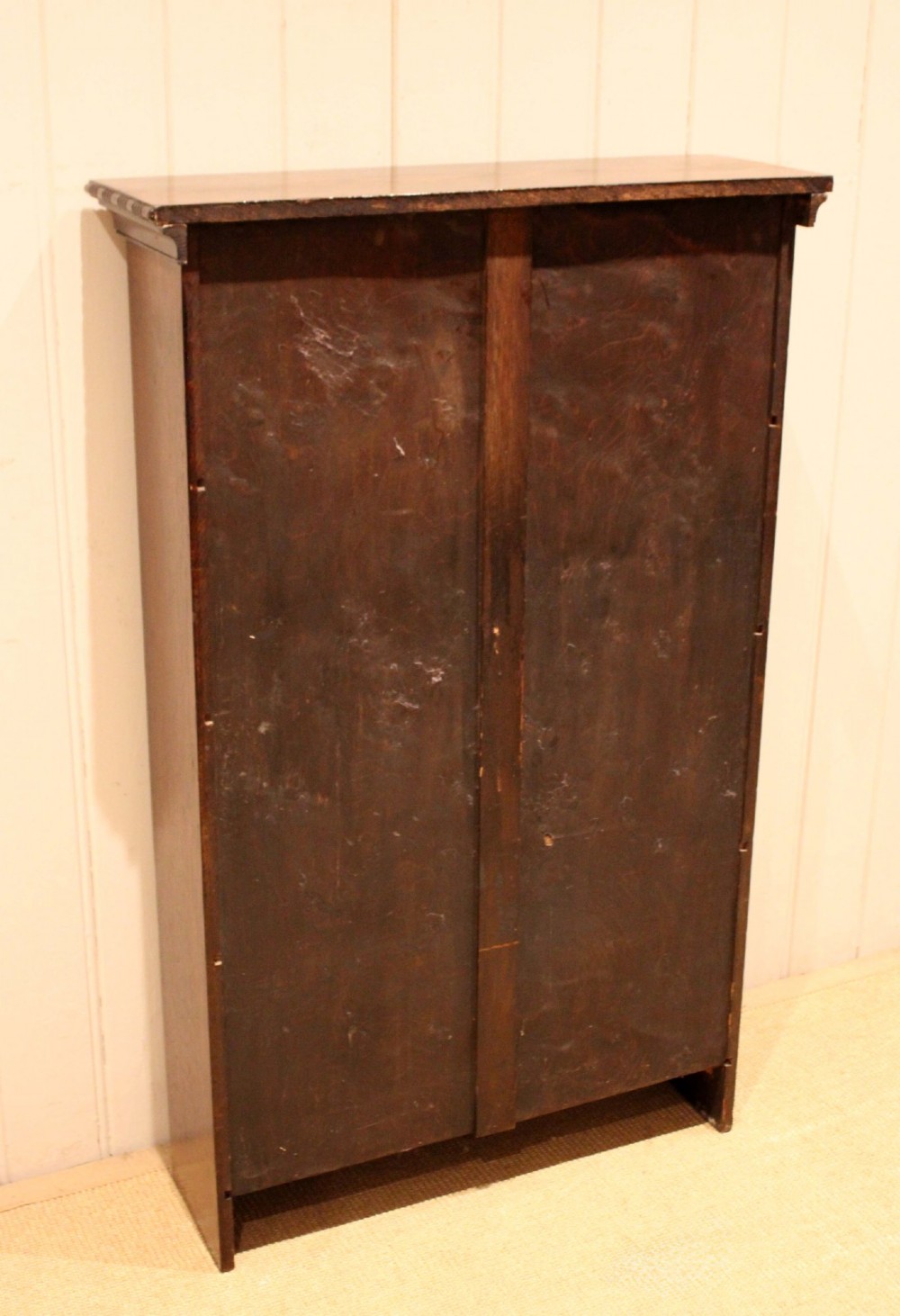 An antique dark oak open bookcase featuring four fixed shelves decorated with beaded edge mouldings and a shaped base plinth. View XII